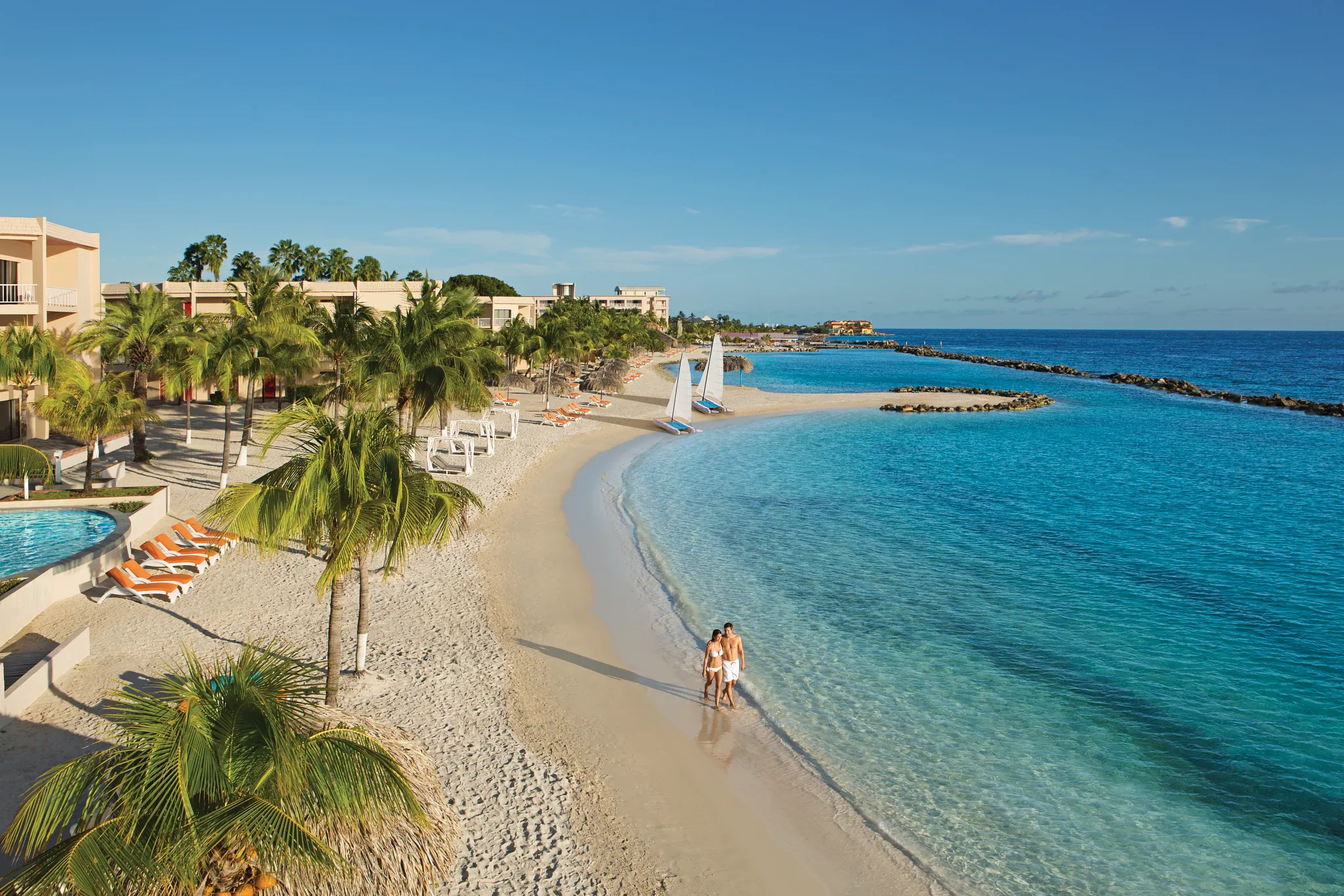 Couple walking along the beach at Sunscape Curaçao Resort, Spa & Casino in the Caribbean.