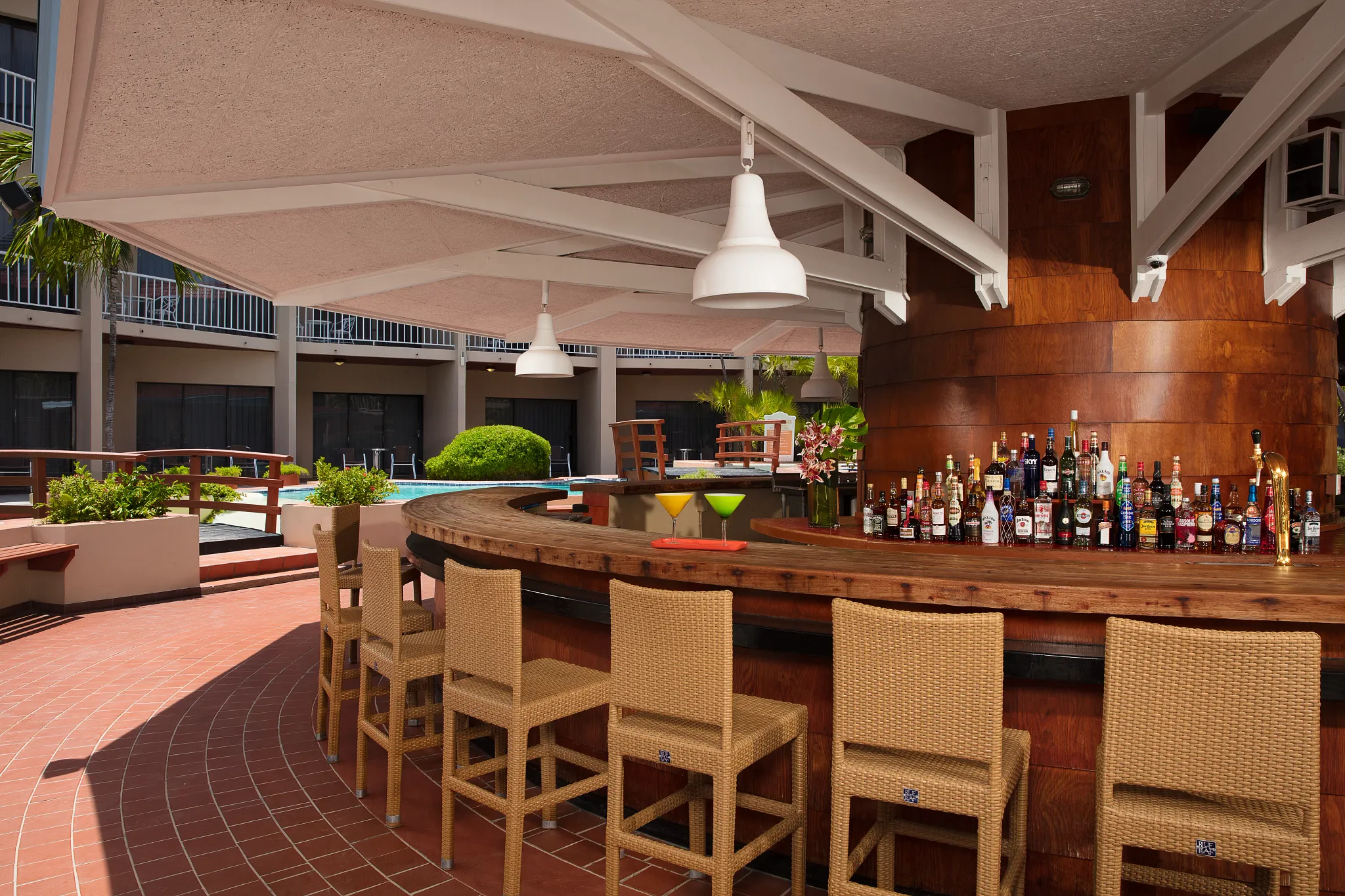 Oceana Bar at Sunscape Curaçao Resort featuring an open-air wooden bar with tropical cocktails near the resort pool and restaurant terrace.