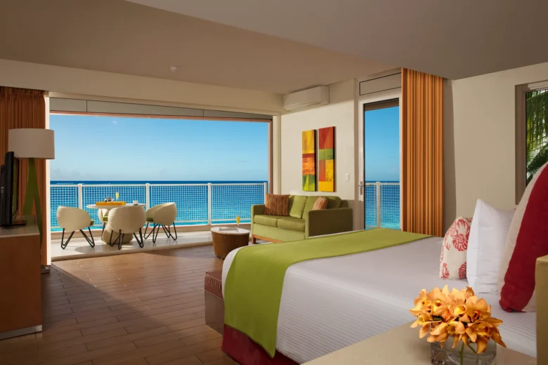 Sun Club Honeymoon Junior Suite Ocean Front interior with king bed, seating area, and balcony overlooking the Caribbean Sea at Sunscape Curaçao Resort.