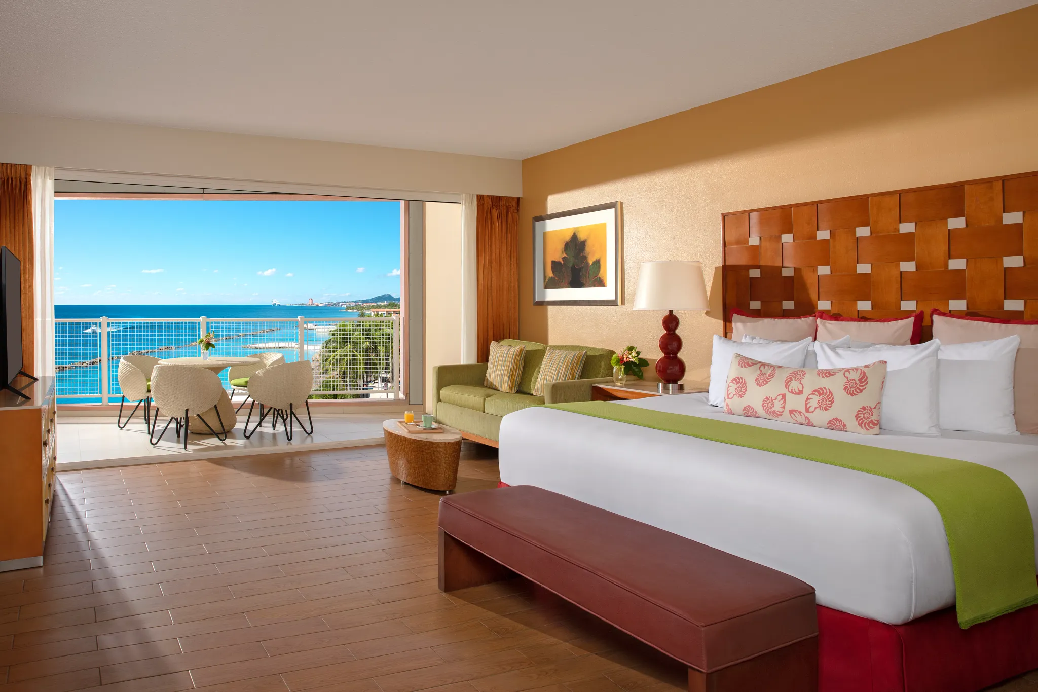 Sun Club Junior Suite Ocean View with double bed, sitting area, and balcony overlooking the ocean at Sunscape Curaçao Resort.