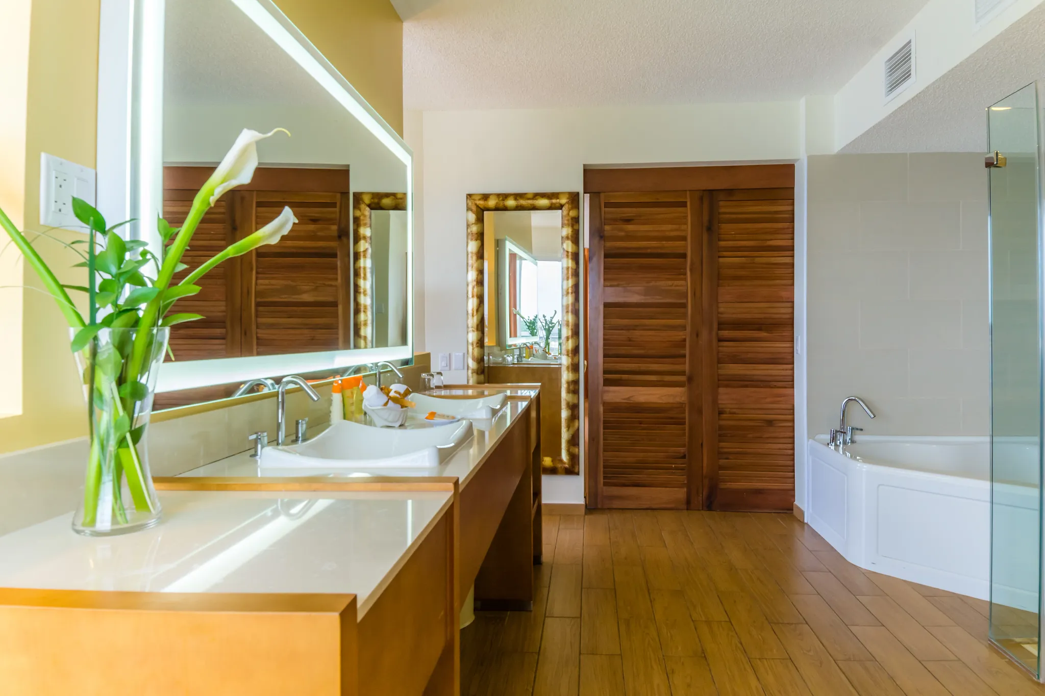 Sun Club Master Suite Ocean Front double vanity bathroom with illuminated mirror and soaking tub at Sunscape Curaçao Resort.
