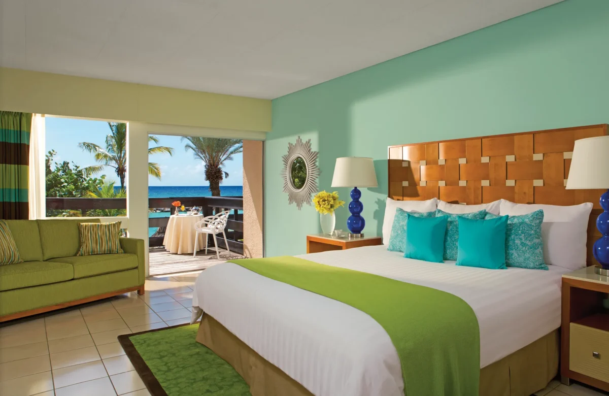 Sun Club Premium Deluxe Ocean Front king bedroom with seating area and ocean-view terrace at Sunscape Curaçao Resort.