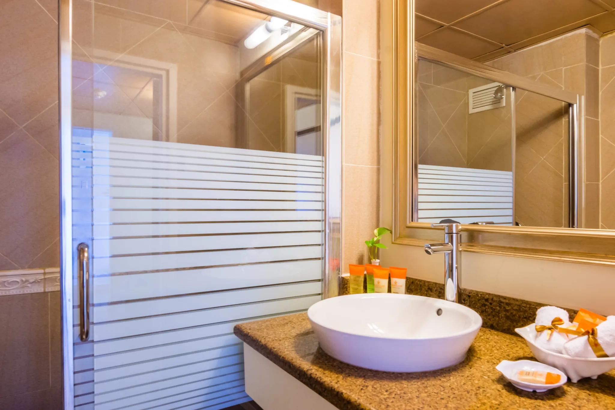Sun Club Suite Ocean Front bathroom with vanity sink, mirror, and glass shower at Sunscape Curaçao Resort.